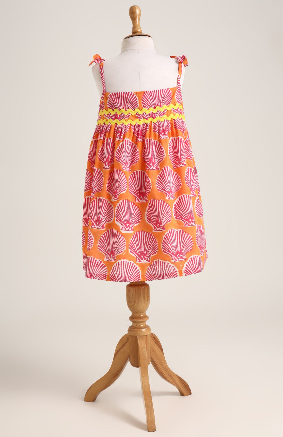 Printed cotton dress. Detailed with colourful strings on shoulder and  tied bow straps.
